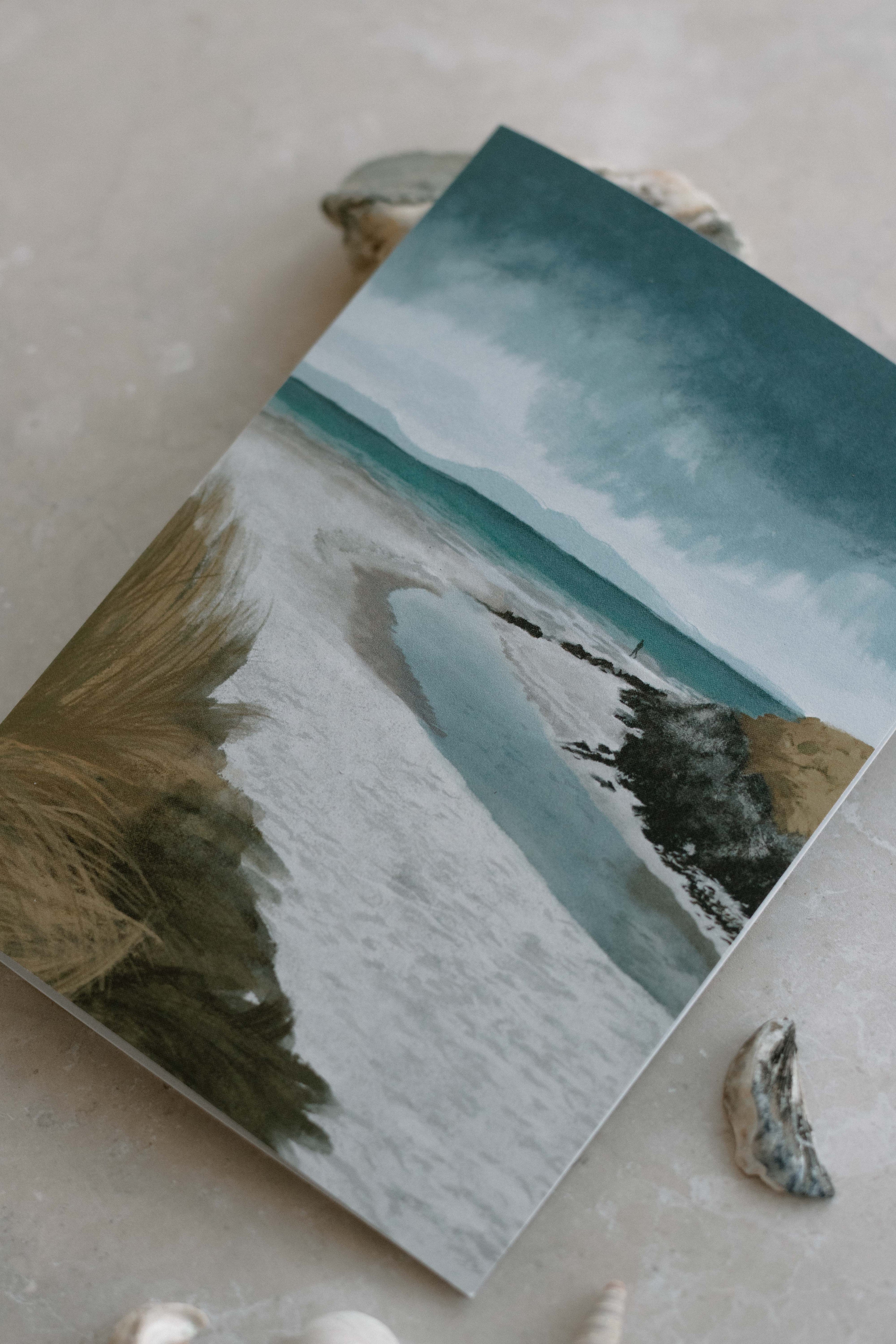 Card with stormy beach scene on a textured surface