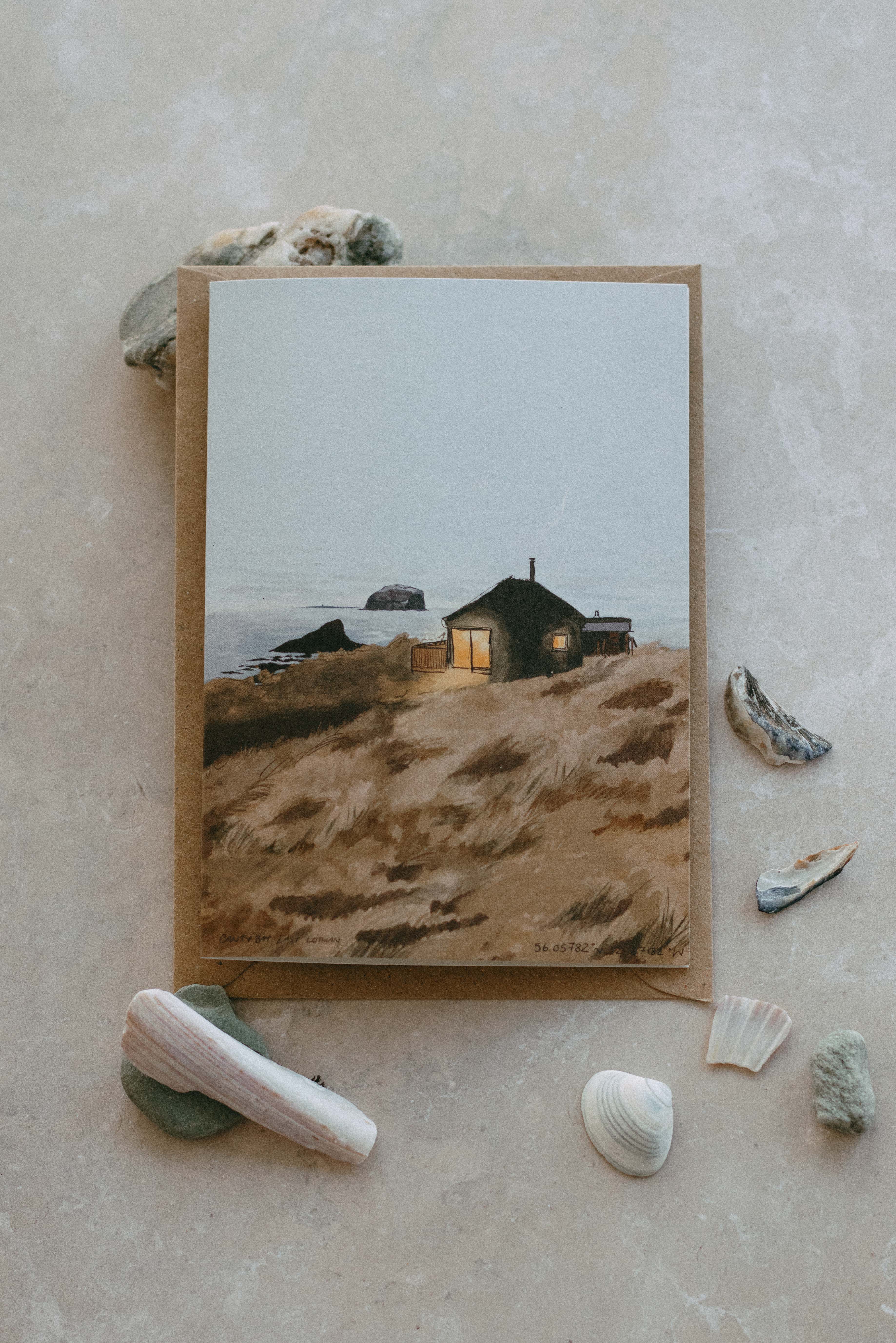 Illustration of a coastal scene with a house on the dunes, surrounded by seashells on a textured beige surface.