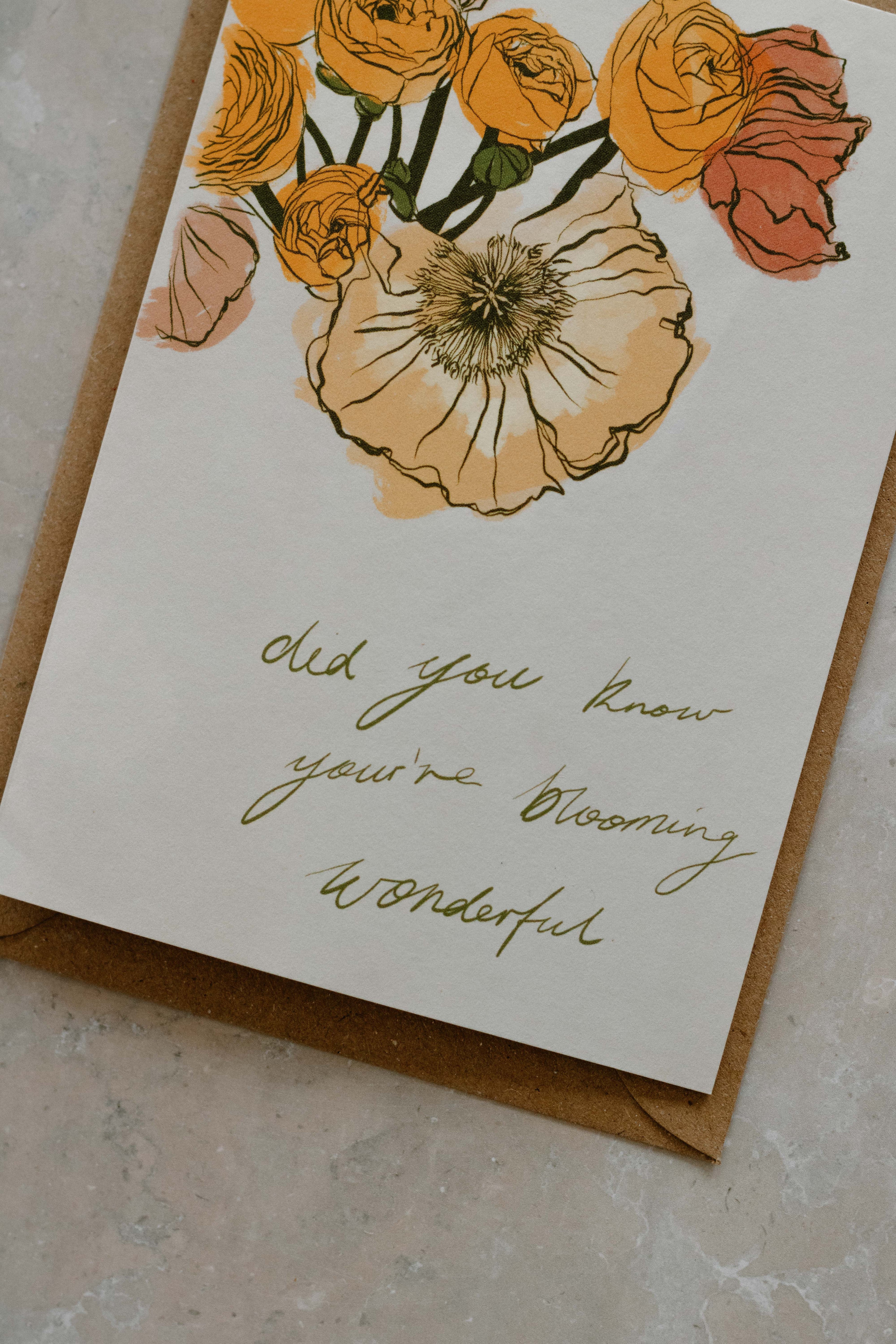 A6 card with the quote “did you know you’re blooming wonderful” on top of a Kraft brown envelope