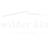 A minimalist logo on a white background featuring a sketched line above the words 'Wilder Kin' in a serif font, with 'EST. STUDIO 2026' below.